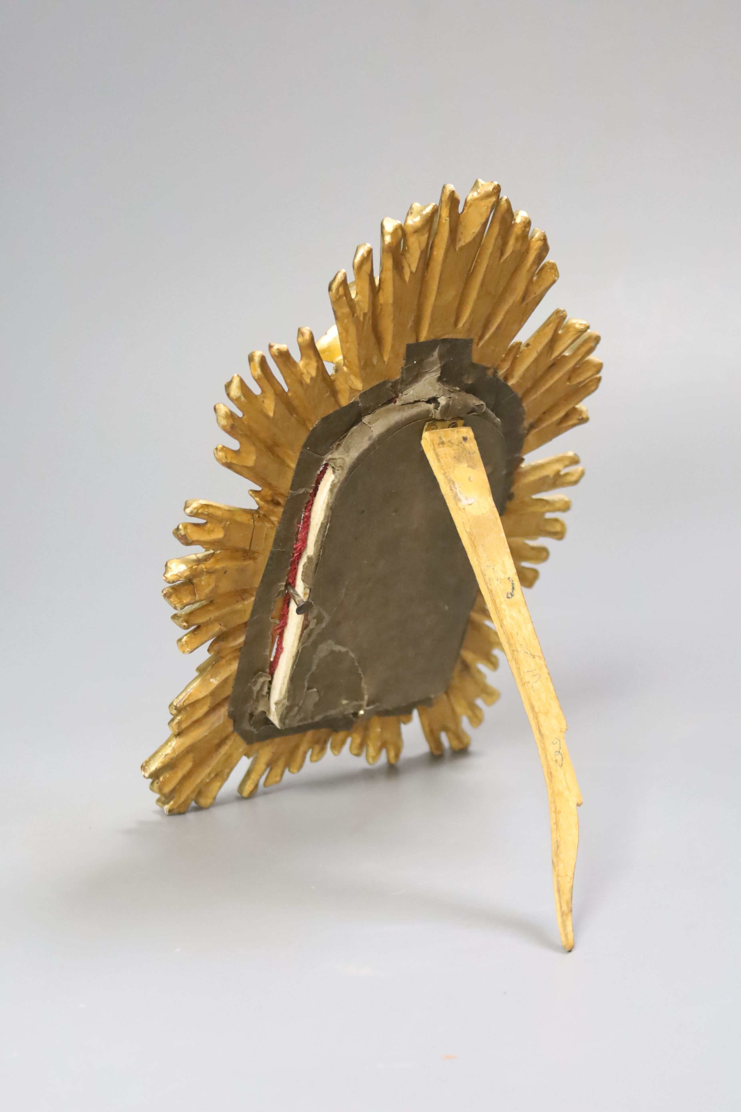A carved ivory relief figure of a maiden emblematic of agriculture, in a giltwood sunburst frame, length 22cm